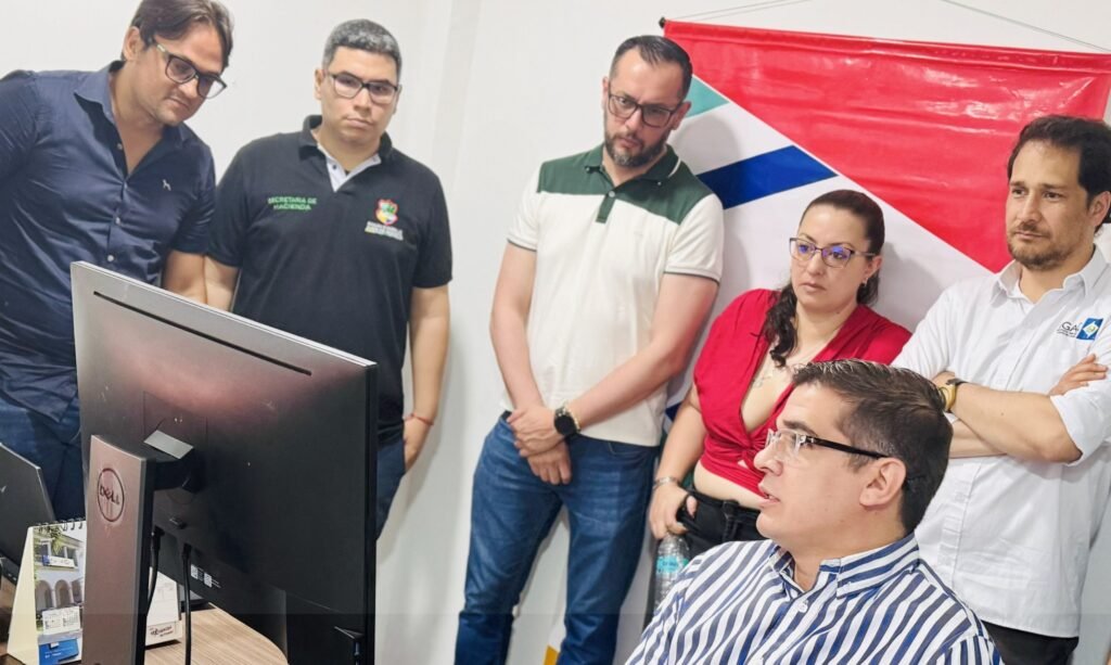 El alcalde de Juan de Acosta, Carlos Higgins, izquierda, observa el software catastral.